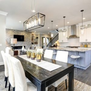 Open-concept dining area and kitchen with dark wood table and white chairs